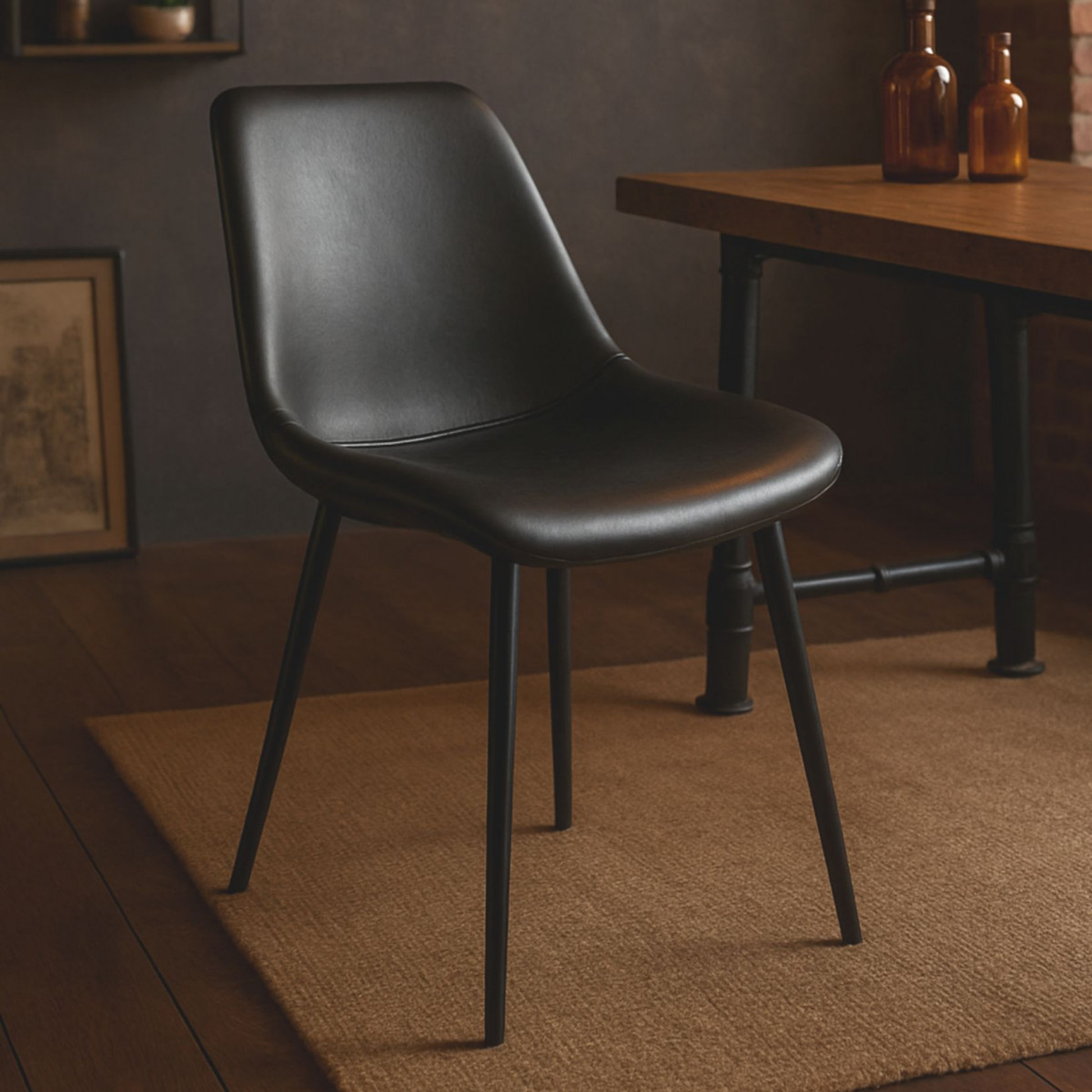 Silla estilo industrial tapizada en polipiel con patas de acero en negro. Estilo vintage industrial capaz de modernizar todas las estancias.